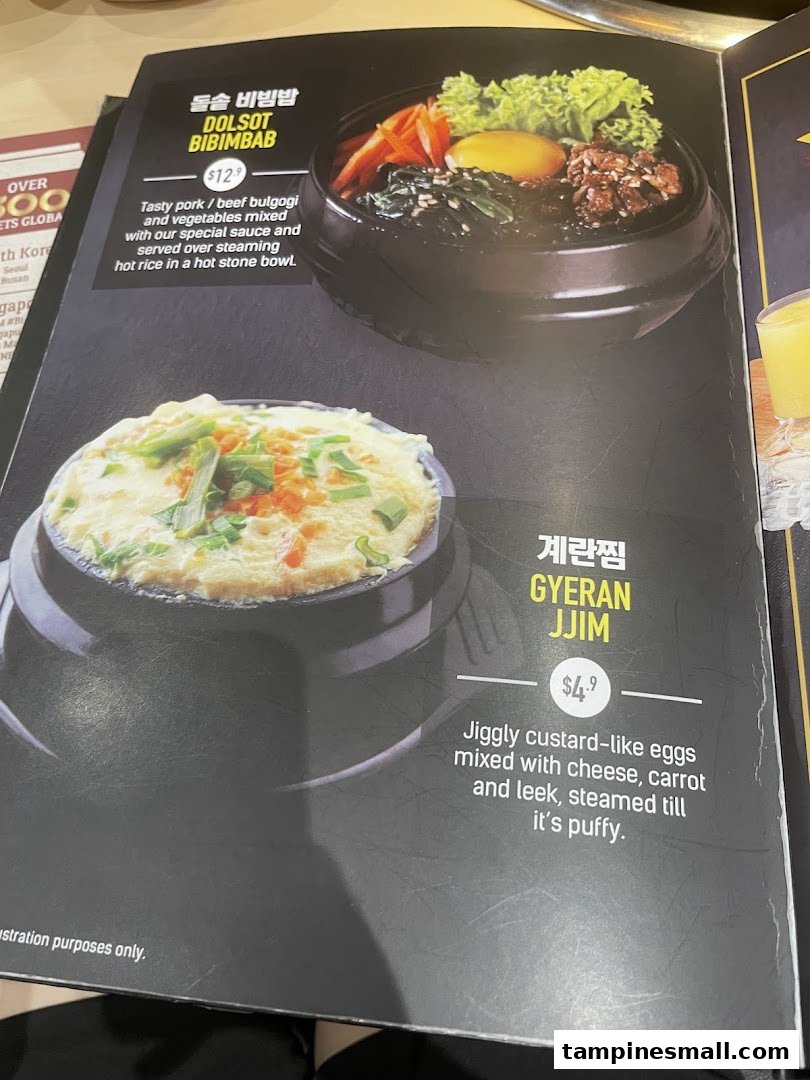 A close-up of a menu page featuring Dolsot Bibimbab and Gyeran Jjim with descriptions and prices.