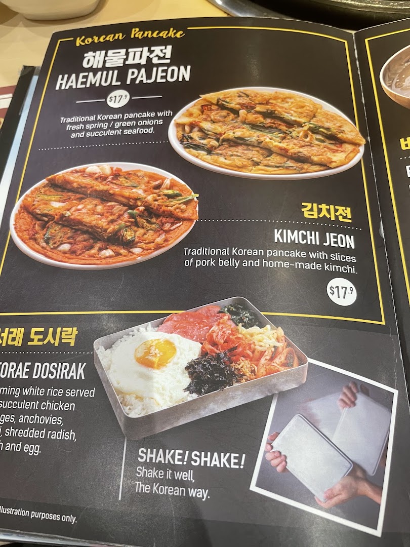 A close-up view of a Korean restaurant menu featuring pancakes and a dosirak meal.
