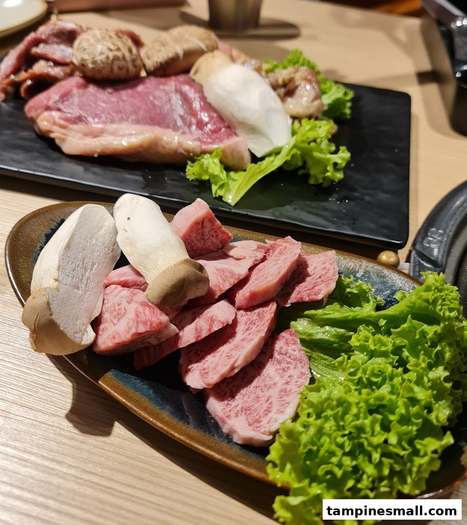 Plates of raw marbled beef, mushrooms, and fresh lettuce, ready for grilling.