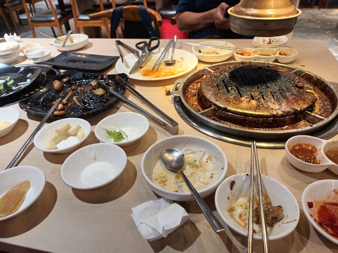 A table at Seorae Jib after a Korean BBQ meal, showing a grill and used dishes.