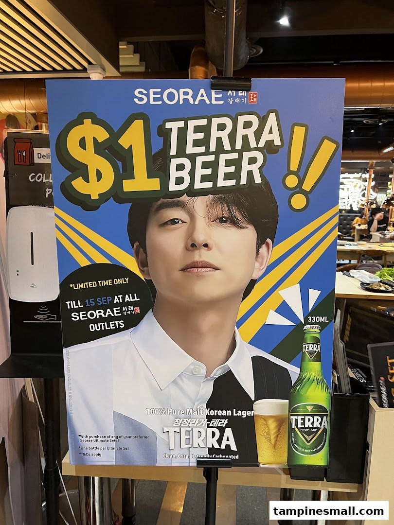 A promotional standee for $1 Terra Beer at Seorae Jib, featuring a celebrity and offer details.