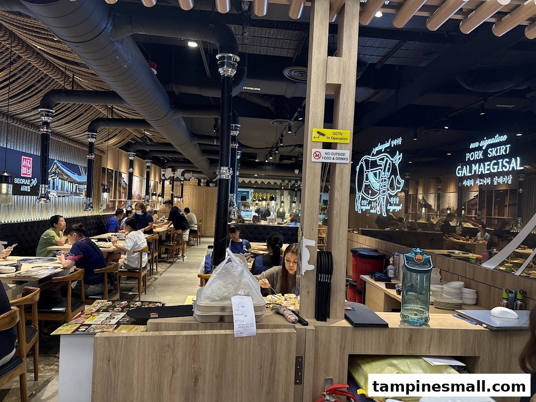 A bustling interior view of Seorae Jib, a Korean BBQ restaurant, with diners enjoying their meals.