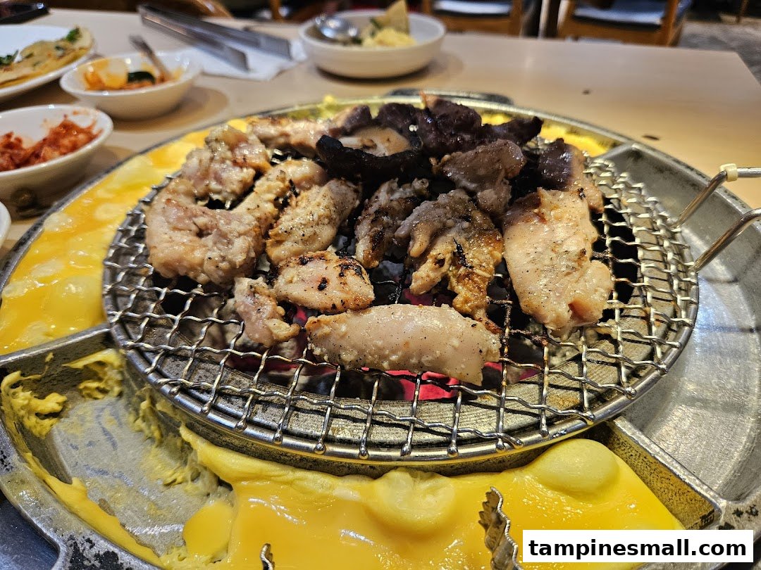 Delicious Korean BBQ grilling on a tabletop with melted cheese and various side dishes.