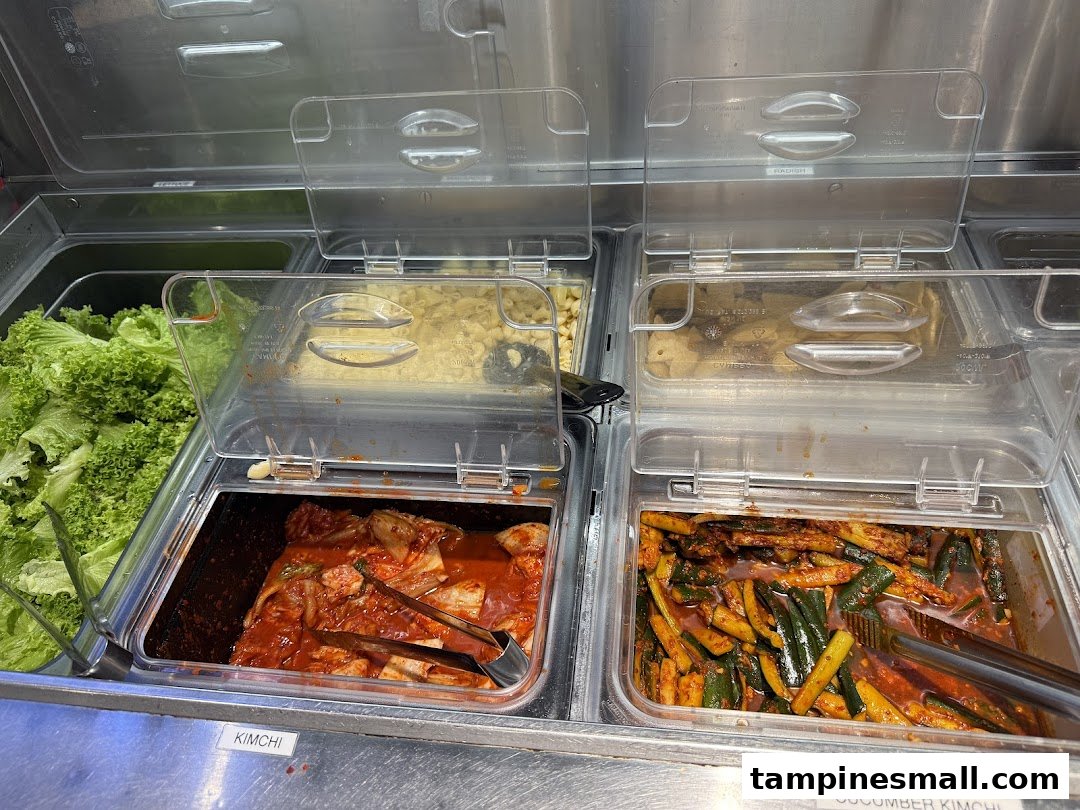 A vibrant display of fresh Korean banchan, including kimchi and cucumber kimchi, ready for self-service.