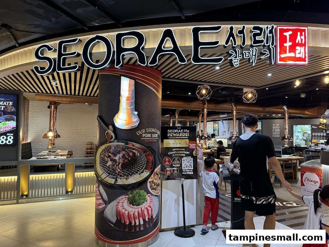 The inviting entrance of Seorae Jib, a Korean BBQ restaurant, featuring its prominent signage and promotional displays.