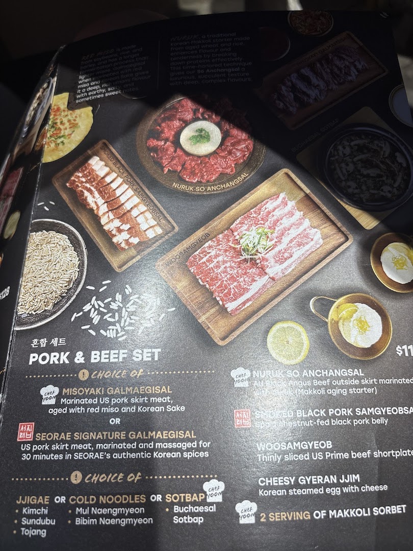 A menu page from Seorae Jib showcasing Korean BBQ meats like pork and beef sets, along with various side dish options.