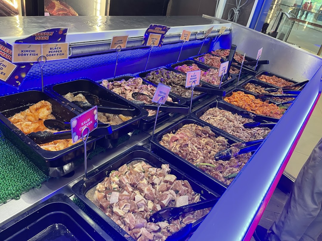 A vibrant display of freshly marinated meats and seafood at Seoul Garden's buffet counter.