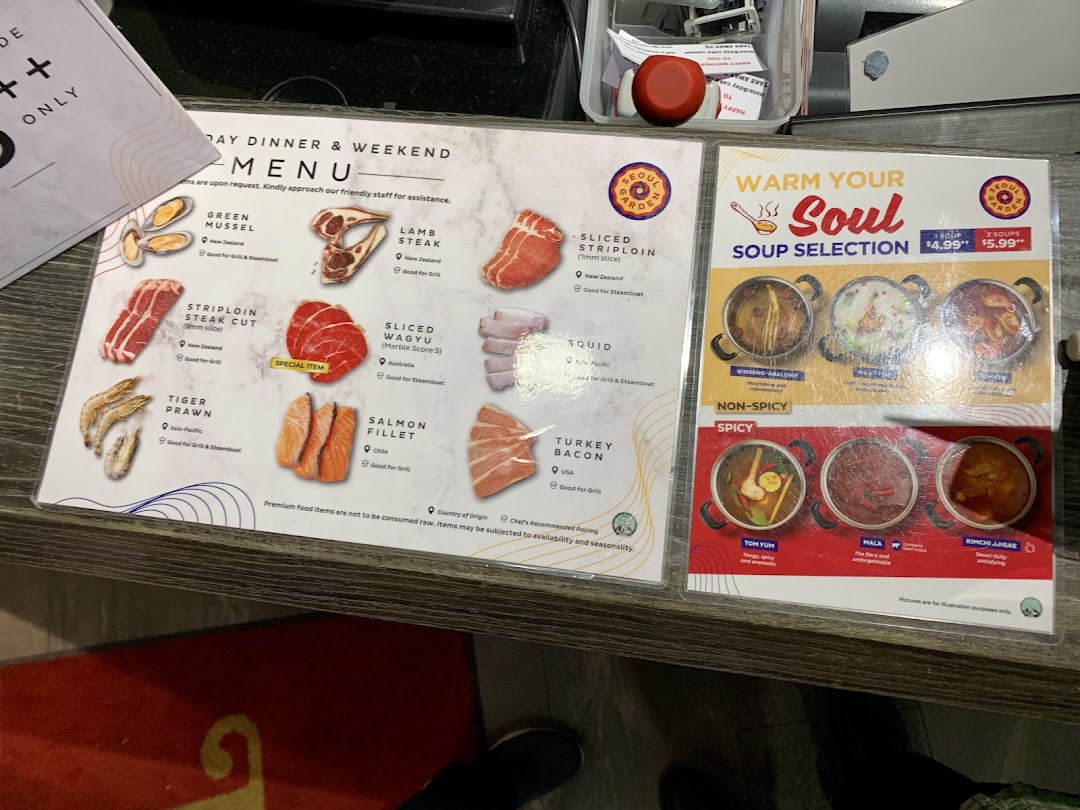 Two menus displayed on a counter, featuring BBQ/steamboat ingredients and soup selections.