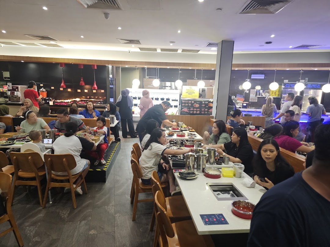 A lively interior shot of Seoul Garden restaurant, showing customers enjoying a buffet hotpot meal.