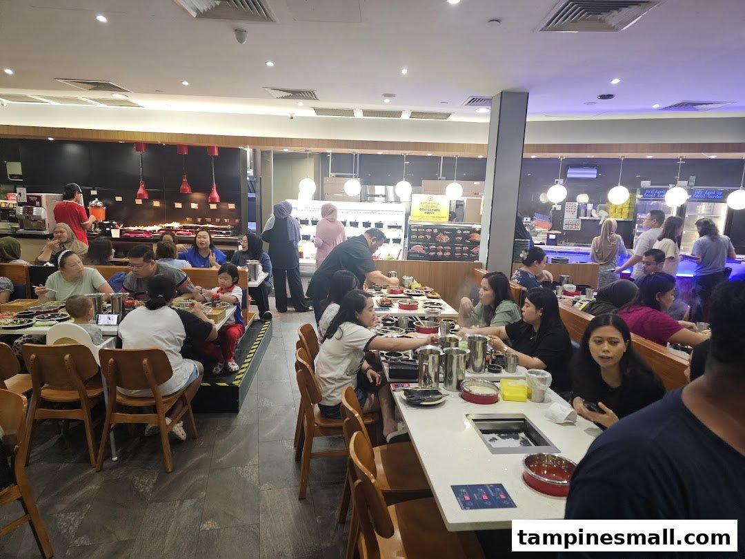 A lively interior shot of Seoul Garden restaurant, showing customers enjoying a buffet hotpot meal.