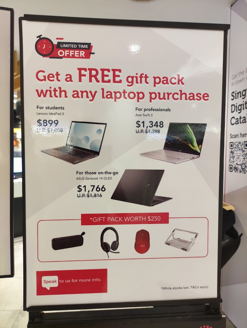 A promotional display offering a free gift pack with laptop purchases, featuring various models and prices.
