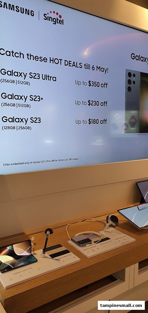 A digital display in Singtel Shop showcasing Samsung Galaxy S23 series hot deals with discounts.