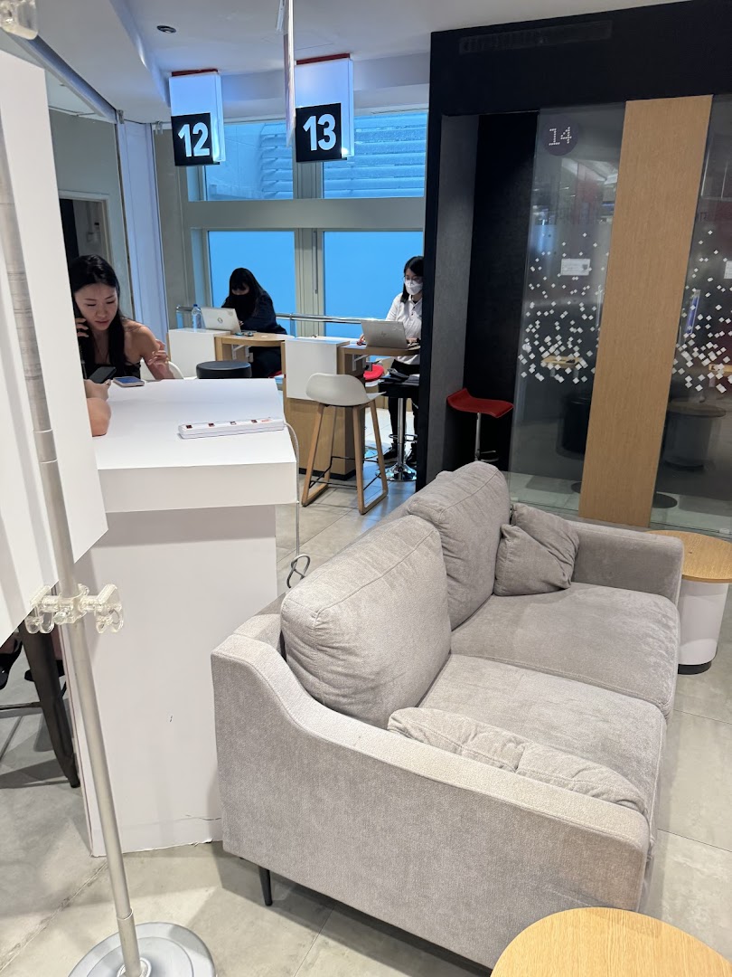 Interior view of Singtel Shop with customer service counters, staff assisting customers, and a comfortable waiting area.