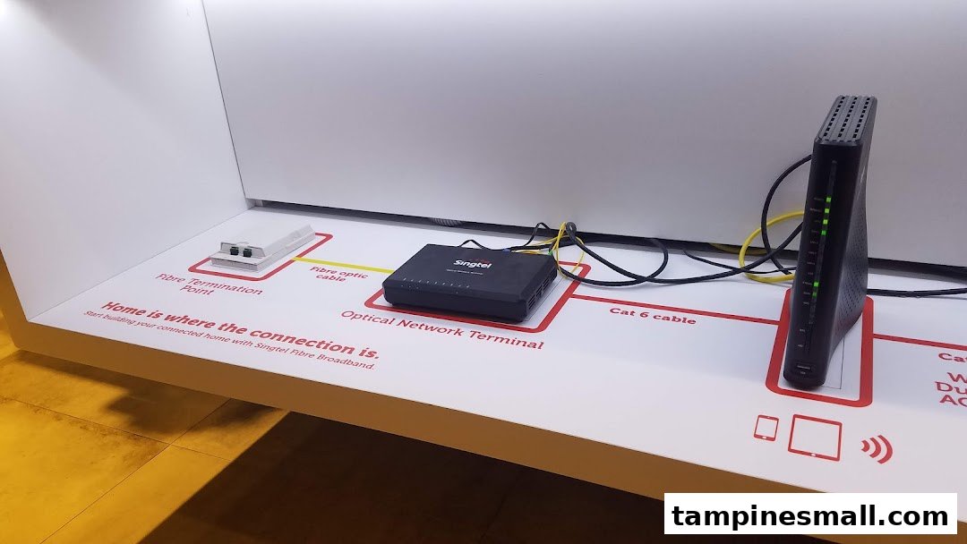 A Singtel in-store display showcasing fibre broadband setup with network devices and connection points.