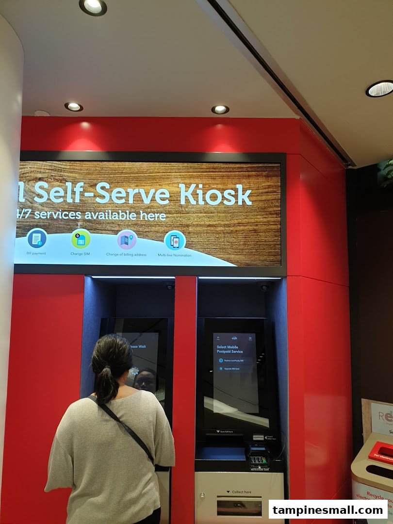 A customer uses a Singtel self-serve kiosk for various mobile services.