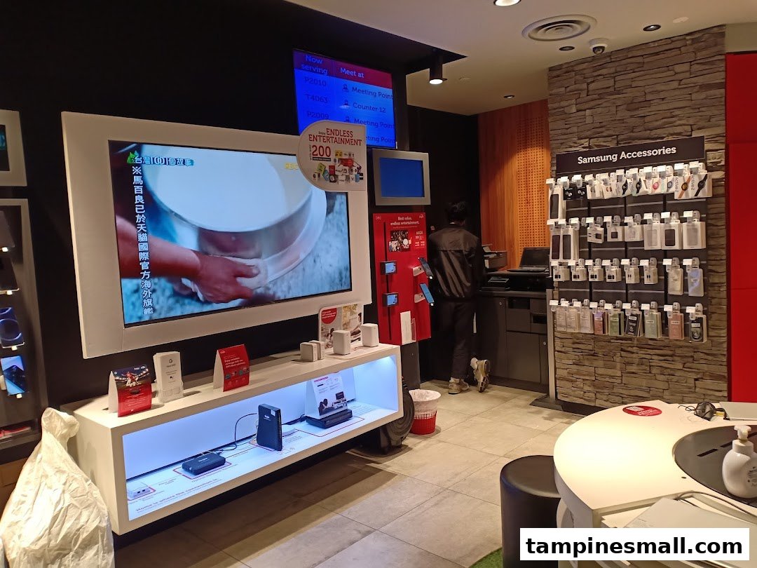 Interior view of a Singtel shop featuring product displays, a large screen, and a staff member.