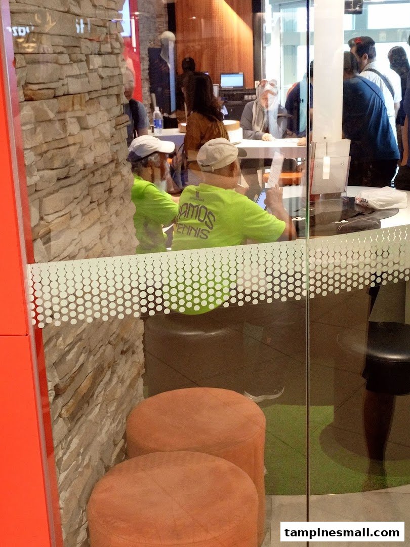 Customers engage with staff inside the Singtel Shop, showcasing active service and consultation areas.