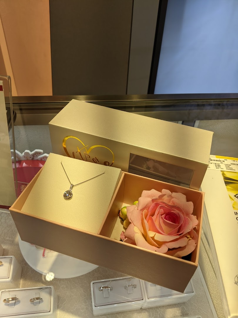 A beautiful diamond necklace and a rose displayed in a gift box, showcasing elegant jewelry.