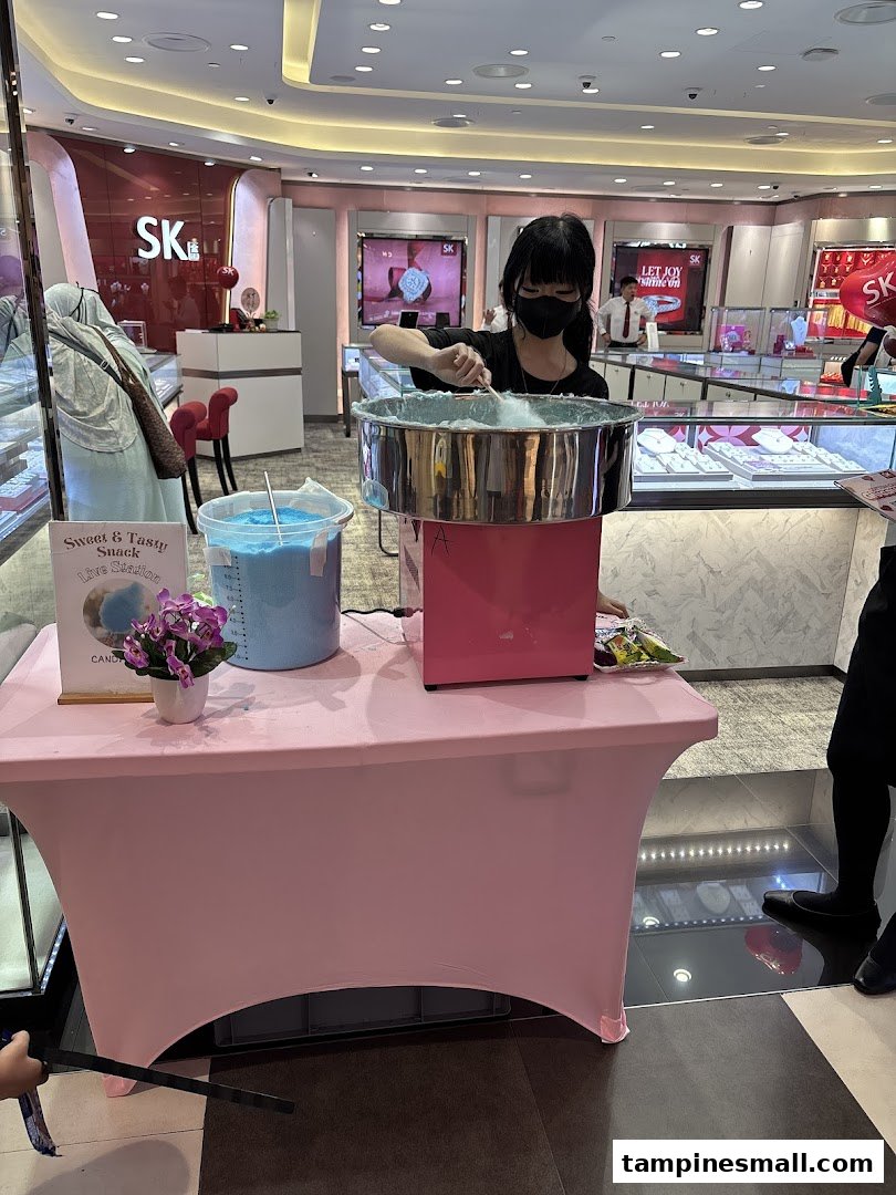 A staff member makes cotton candy at a live station inside SK Gold, offering a sweet treat to visitors.