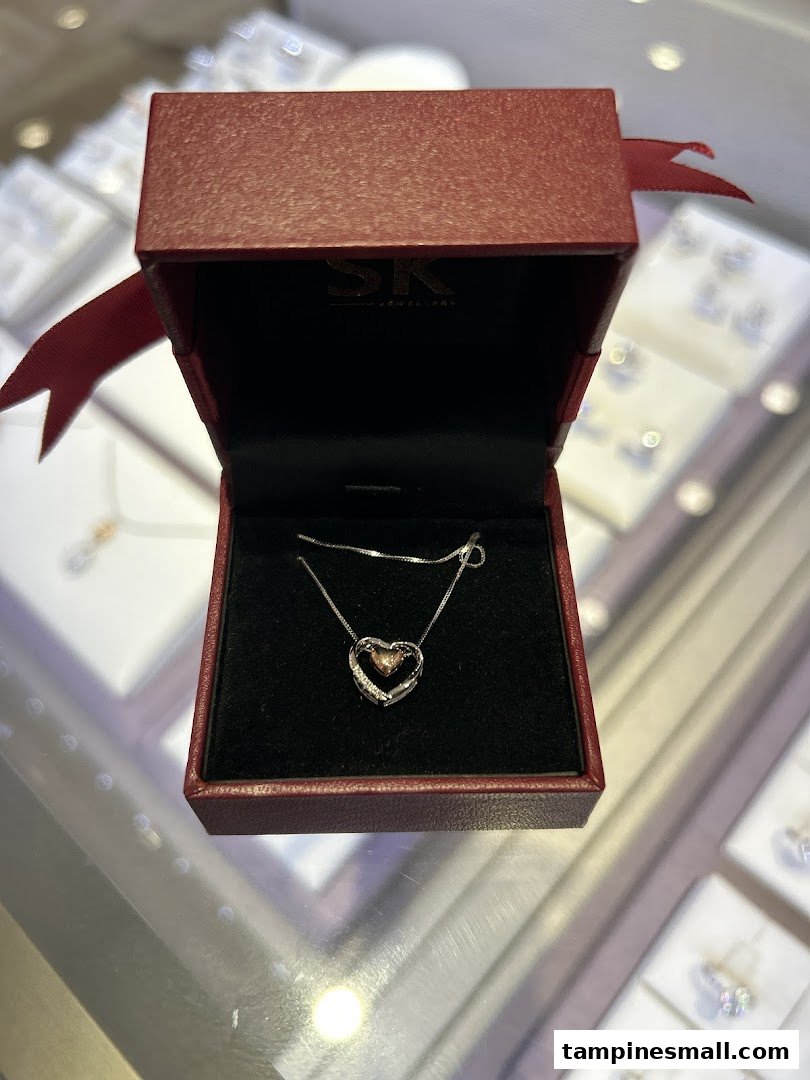 A heart-shaped pendant necklace displayed in a red SK Jewellery box, showcasing exquisite craftsmanship.