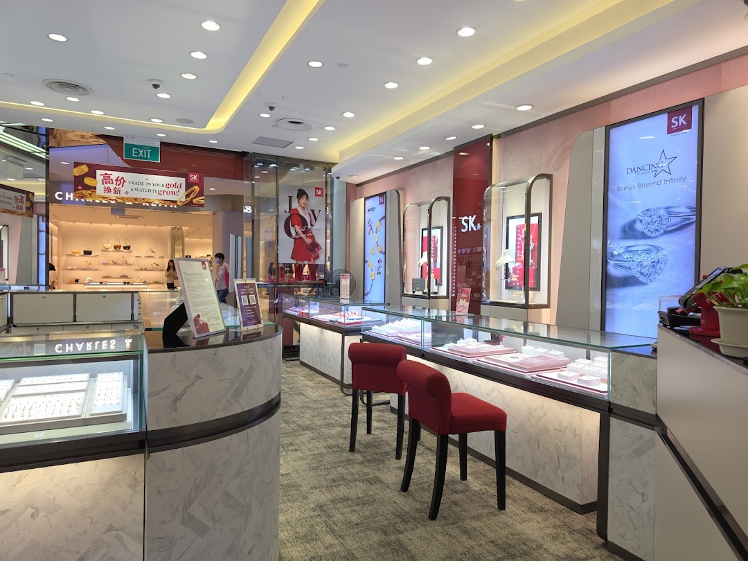 Interior view of SK Gold jewelry store, showcasing display cases with gold and diamond pieces and promotional posters.