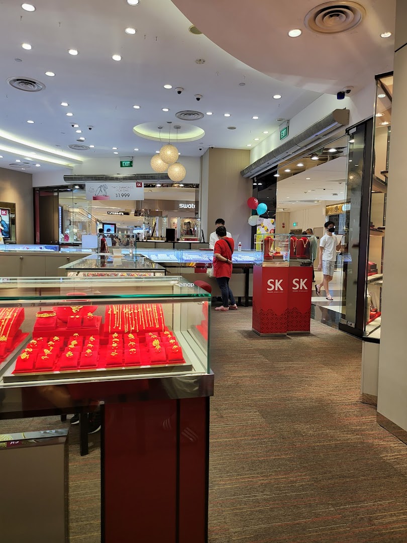 Interior view of SK Jewellery showcasing gold jewelry displays and customers browsing.