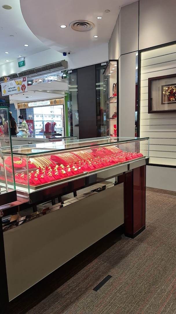 A glass display case showcasing a variety of gold jewellery, including bracelets and rings, inside SK Jewellery.
