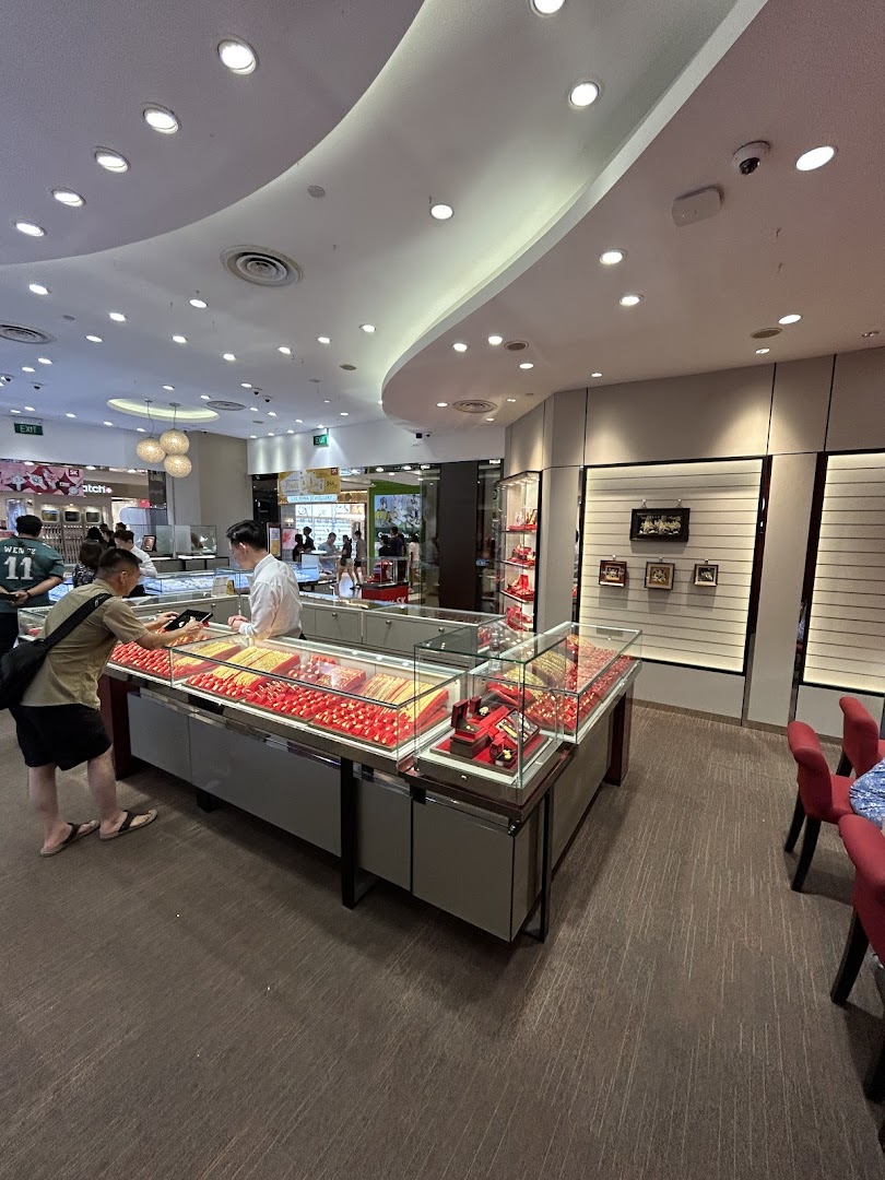 Interior view of SK Jewellery with customers browsing brightly lit gold and gemstone display cases.