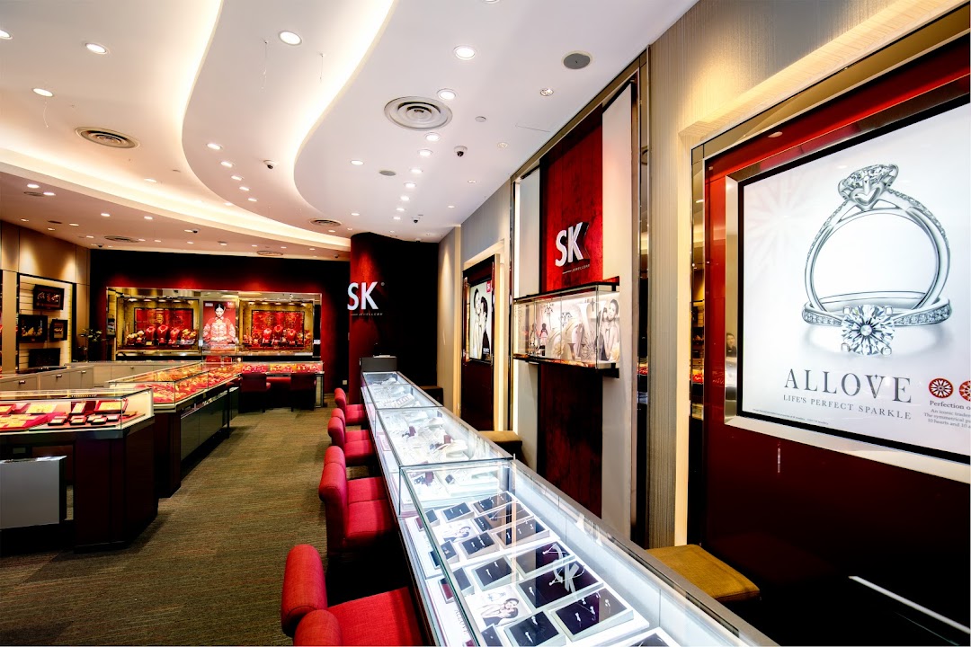 Interior view of SK Jewellery shop featuring display cases, red seating, and a large diamond ring advertisement.