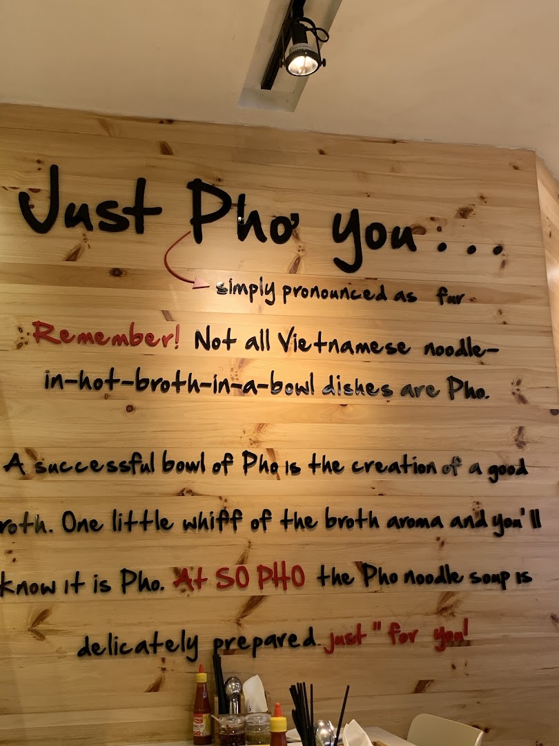 A wooden wall inside So Pho featuring text that explains the authenticity and essence of their Pho.