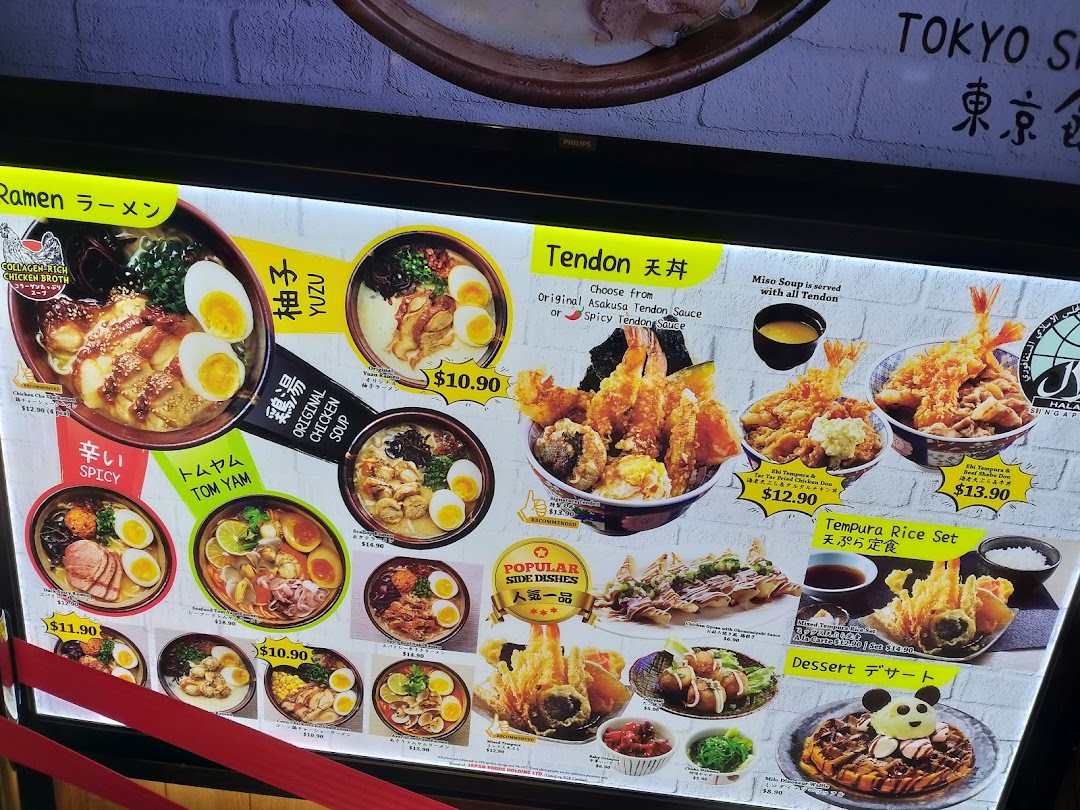 A brightly lit menu board showcasing a variety of Japanese ramen, tendon, tempura, and desserts.