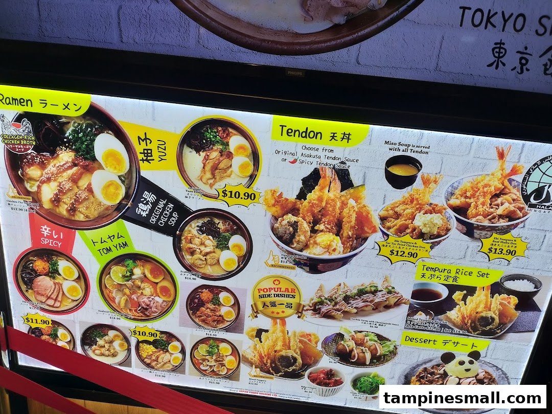 A brightly lit menu board showcasing a variety of Japanese ramen, tendon, tempura, and desserts.