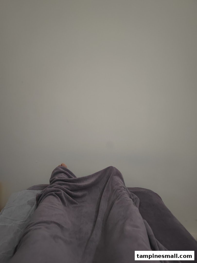 A person covered in a blanket on a treatment bed, suggesting a wellness session.