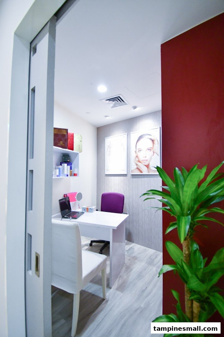 A modern, clean consultation room with a desk, chairs, and wellness-themed decor.
