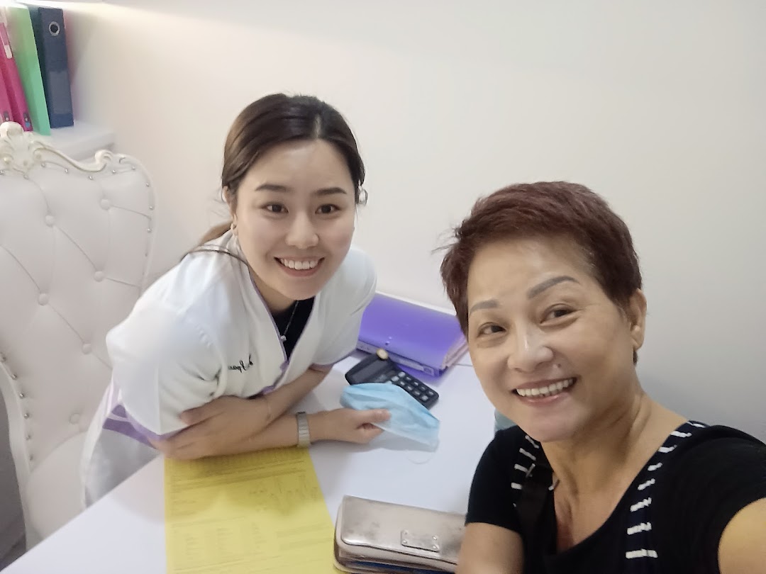 Two smiling women, likely staff and client, in a consultation setting at Spacio TCM Wellness.