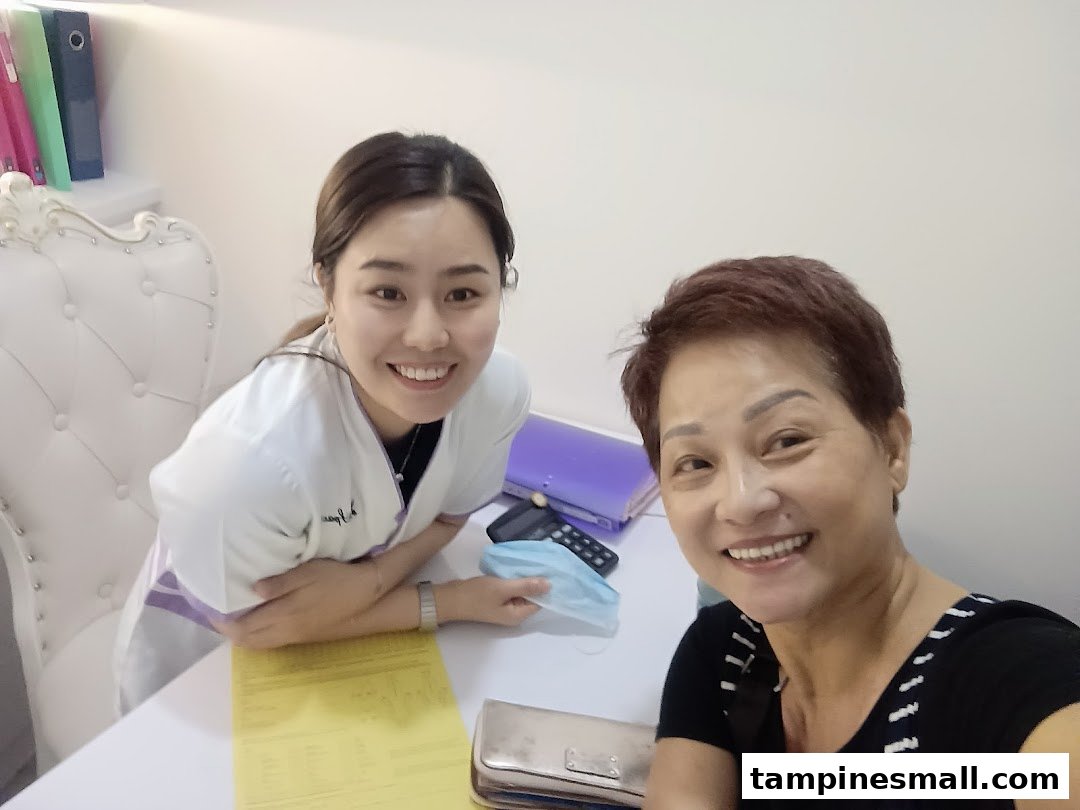 Two smiling women, likely staff and client, in a consultation setting at Spacio TCM Wellness.