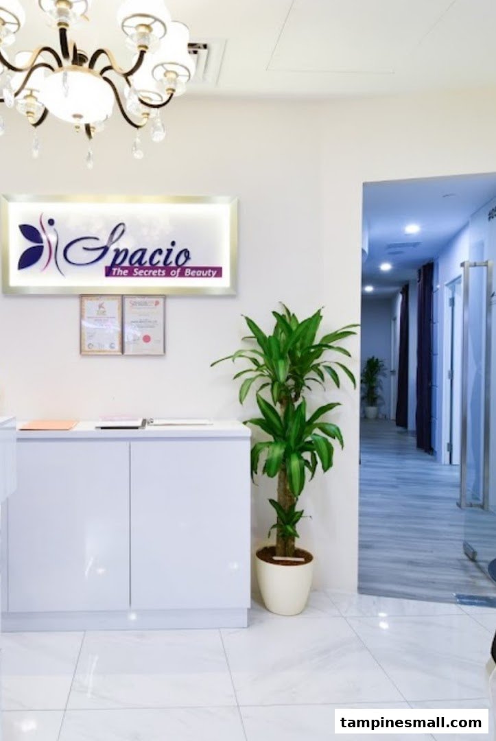 Clean and inviting reception area of Spacio TCM Wellness, featuring a bright sign, white counter, and green plant.
