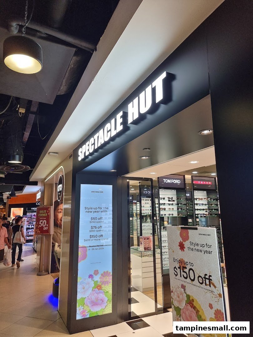 The brightly lit entrance of Spectacle Hut, an optical shop, showcasing eyewear and promotional offers.