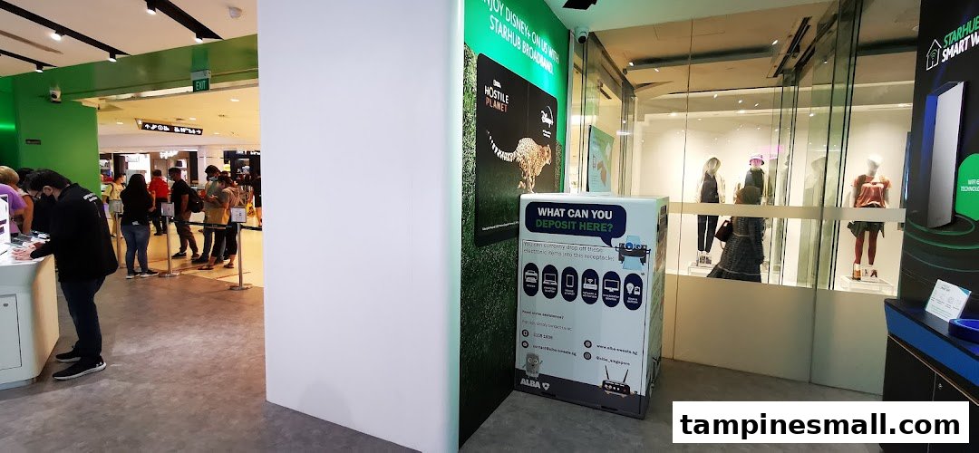 Interior view of StarHub Tampines Mall, showing customers, product displays, and an e-waste recycling bin.