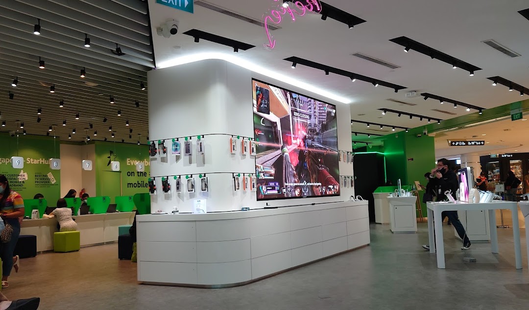 Interior view of StarHub store featuring a large display screen, mobile accessories, and customer service counters.
