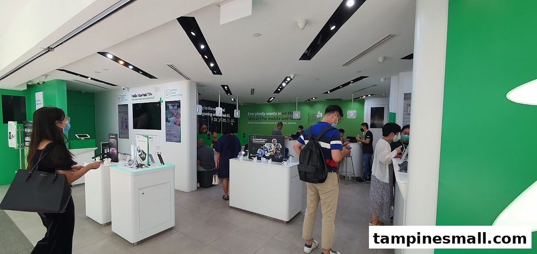 Customers browse mobile devices and interact with staff inside the modern StarHub telecommunications store.