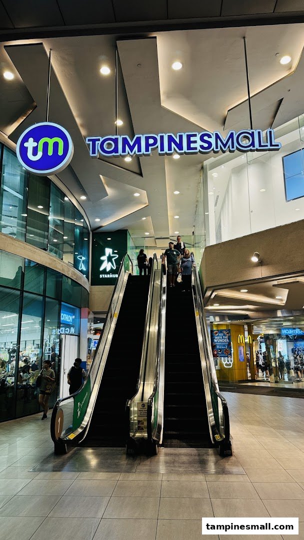 An interior view of Tampines Mall featuring escalators leading to the StarHub store, with other shops visible.