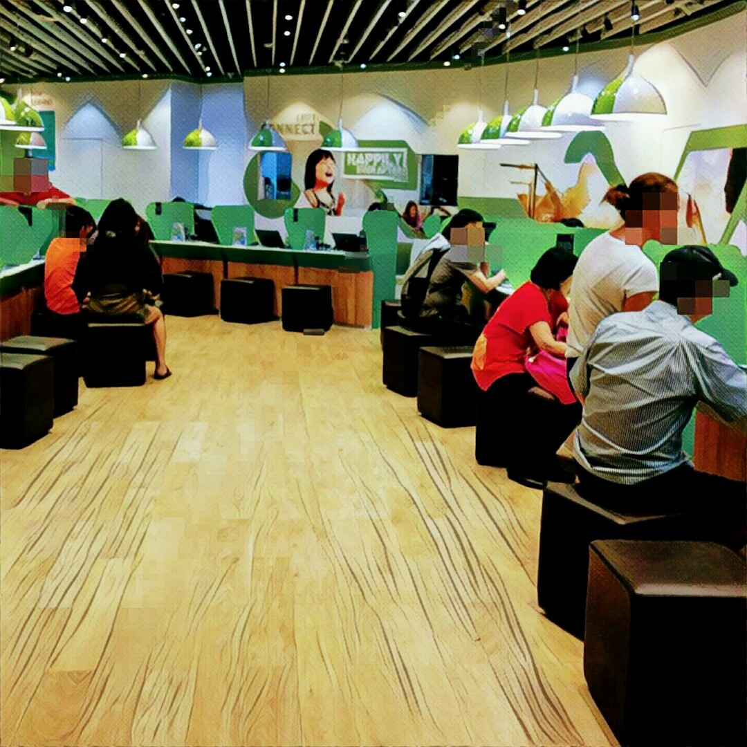 Customers are seated at interactive stations inside the StarHub retail store, engaging with services.