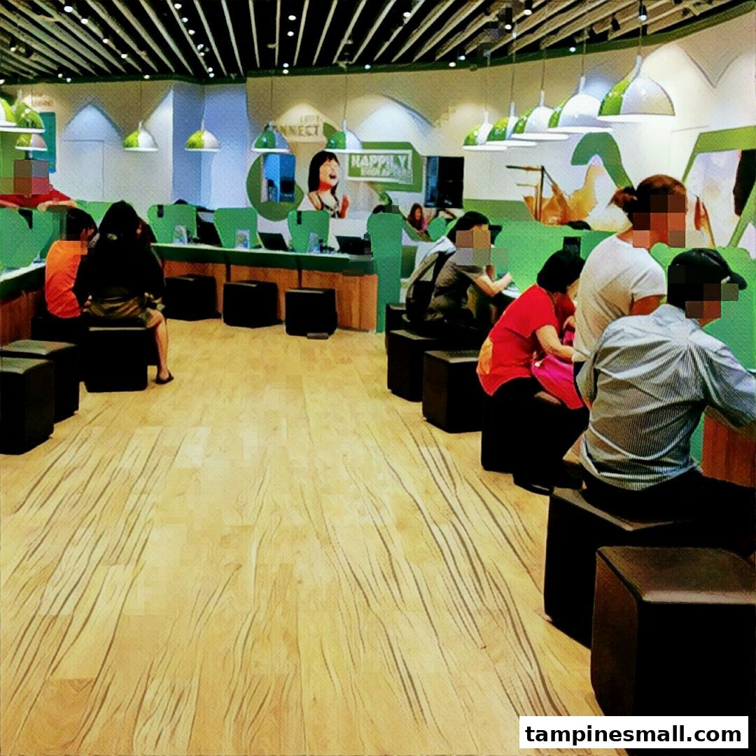 Customers are seated at interactive stations inside the StarHub retail store, engaging with services.