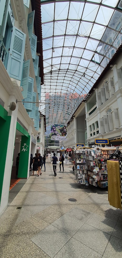 A view of the StarHub shop entrance within a bustling covered pedestrian walkway with traditional architecture.