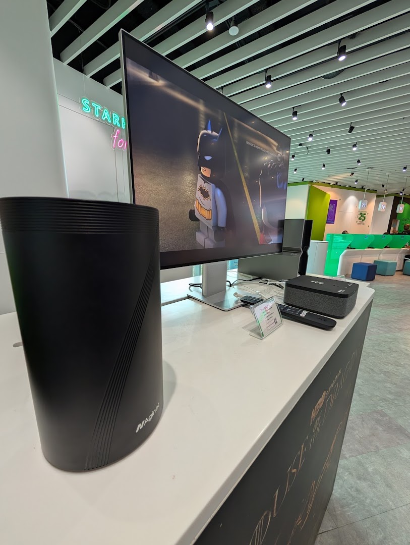 An in-store display at StarHub featuring a router, TV playing Lego Batman, and modern interior.