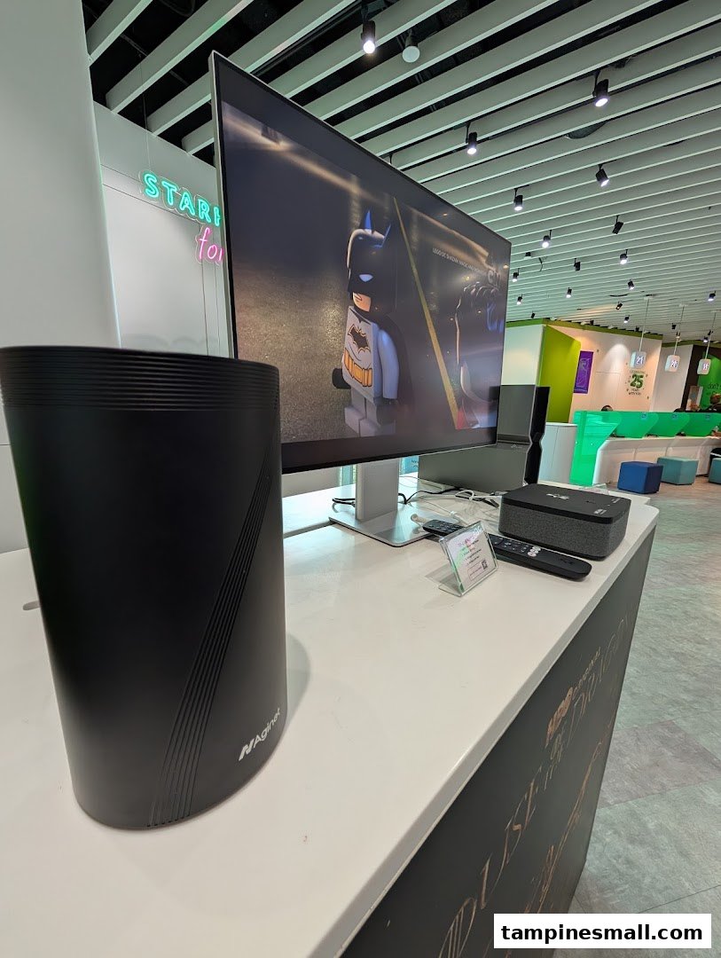 An in-store display at StarHub featuring a router, TV playing Lego Batman, and modern interior.