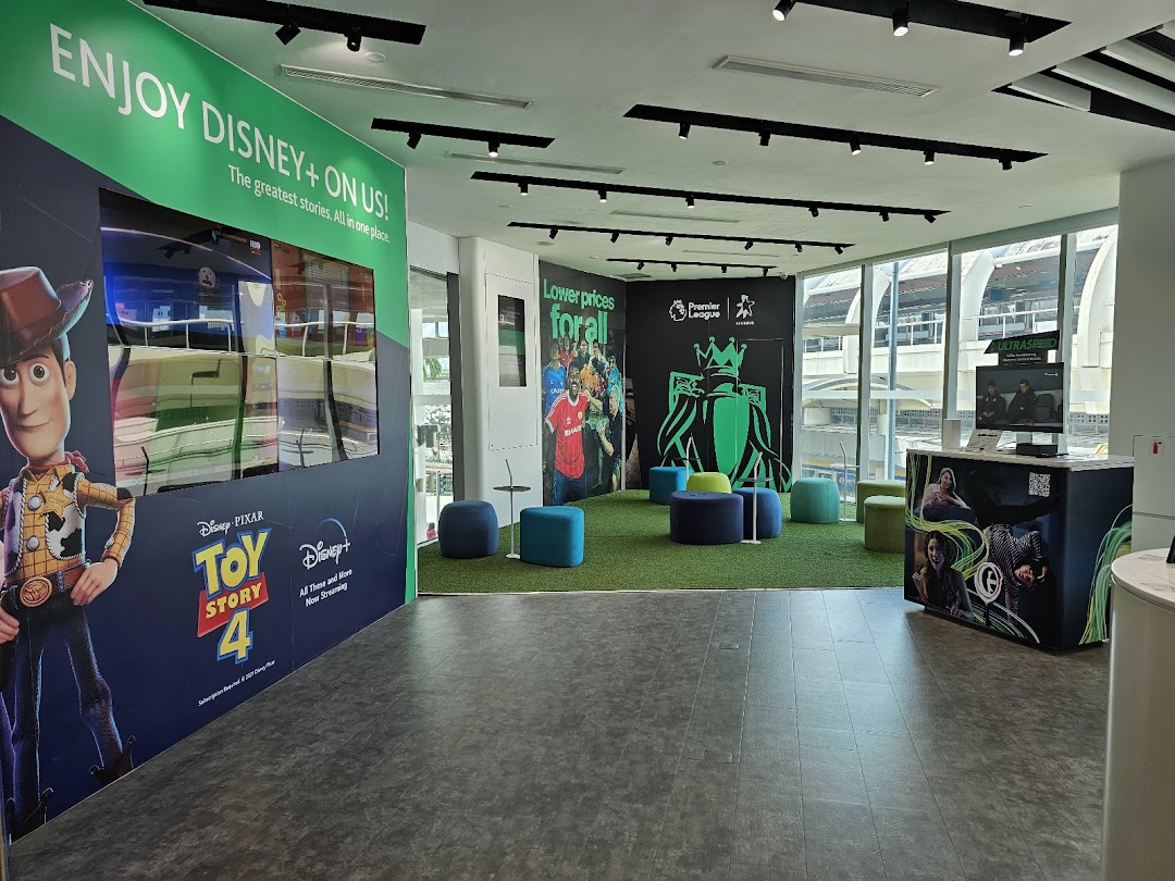 Modern StarHub interior featuring Disney+ and Premier League displays, with a comfortable seating area.
