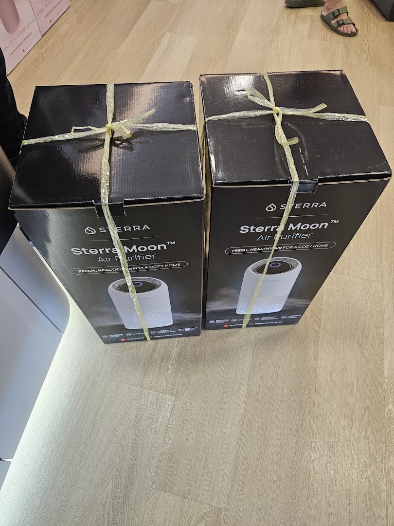 Two Sterra Moon Air Purifier boxes displayed on a light wooden floor.