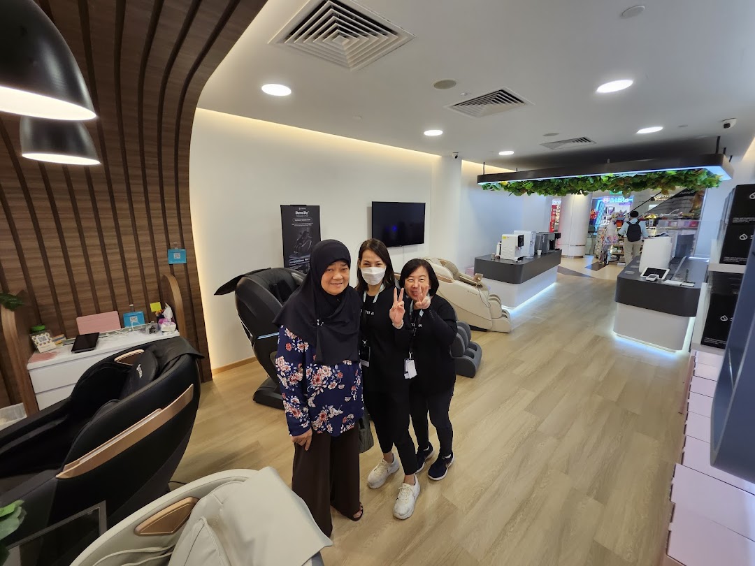 Three individuals pose inside Sterra Singapore, surrounded by modern massage chairs and wellness products.